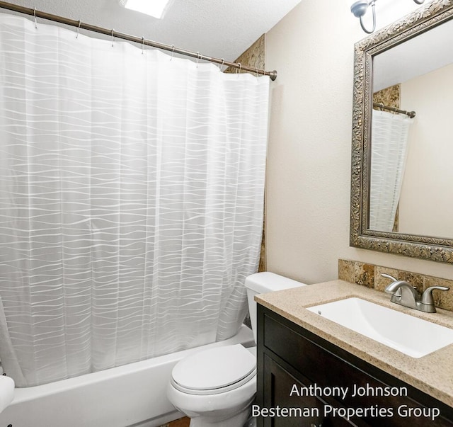 bathroom featuring toilet, shower / bath combo, vanity, and a textured ceiling
