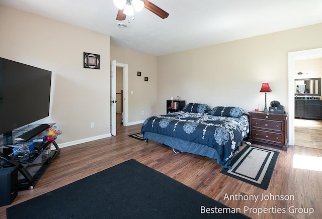 bedroom with wood finished floors, baseboards, a ceiling fan, and ensuite bathroom