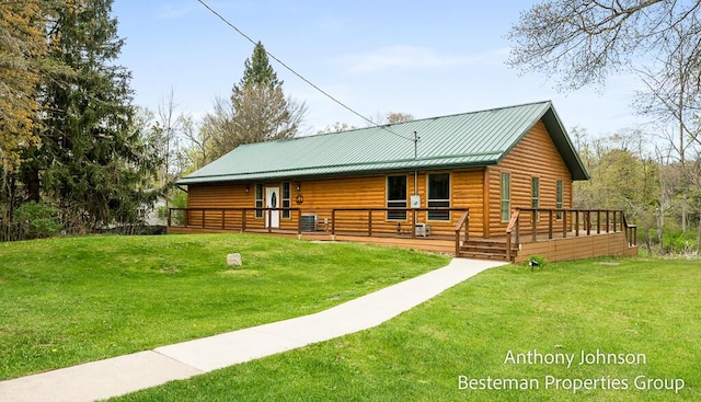 rear view of house with a yard, log veneer siding, and metal roof