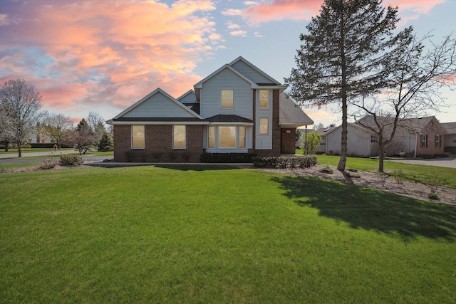 traditional-style house with brick siding and a yard
