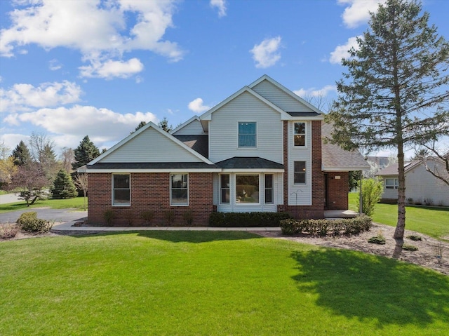 traditional-style house featuring a front yard, brick siding, covered porch, and a shingled roof