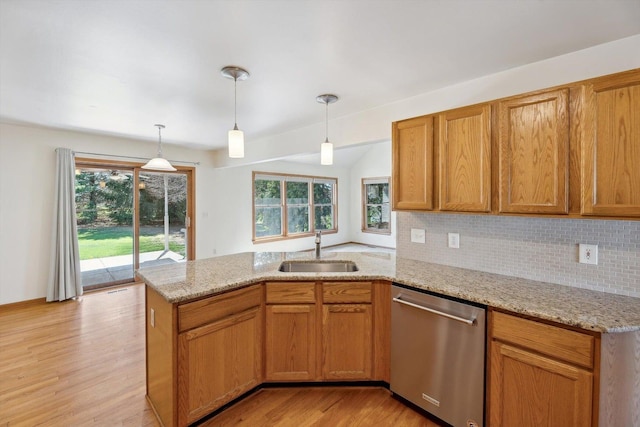 kitchen featuring stainless steel dishwasher, a sink, a peninsula, light wood-type flooring, and healthy amount of natural light