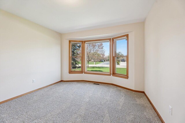 carpeted spare room with baseboards