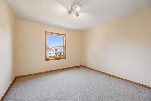 empty room with light carpet and baseboards