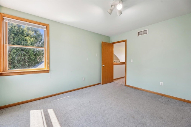 unfurnished room featuring carpet floors and baseboards