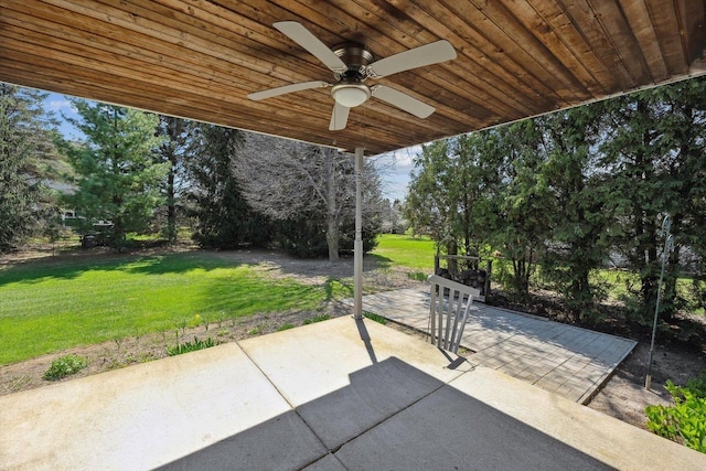 view of patio with a ceiling fan and view of scattered trees