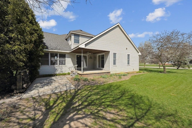 back of property featuring a yard, a patio area, ceiling fan, roof with shingles, and a deck