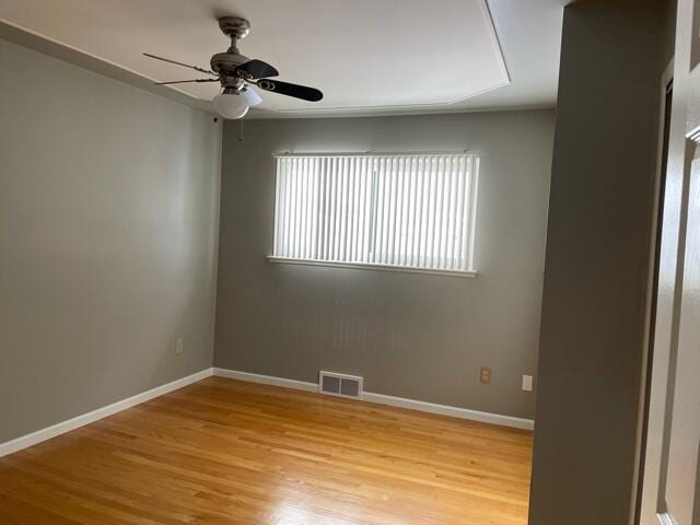 unfurnished room with ceiling fan, light wood-style floors, and baseboards