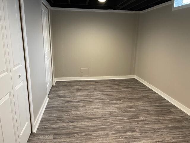 unfurnished room featuring dark wood-type flooring and baseboards