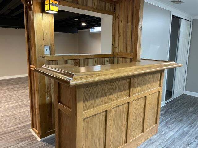 indoor dry bar featuring baseboards and wood finished floors