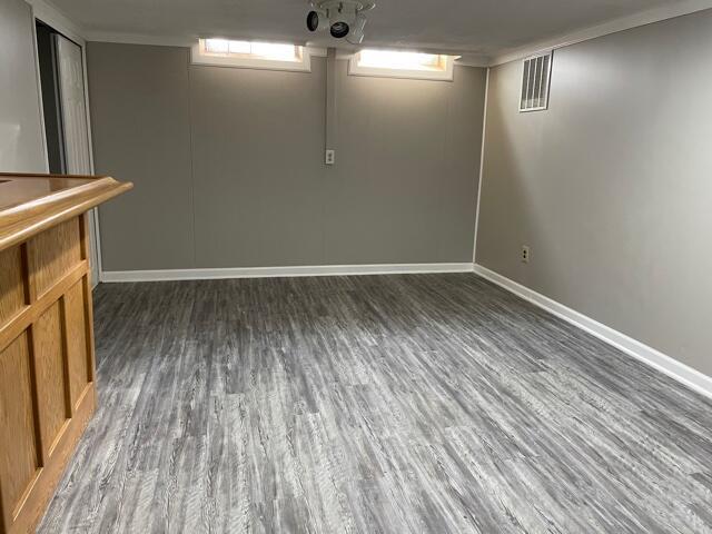 below grade area featuring wood finished floors and baseboards
