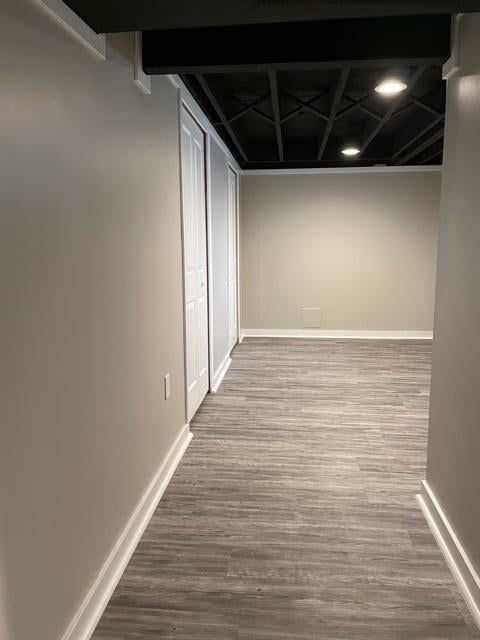 basement with baseboards and wood finished floors