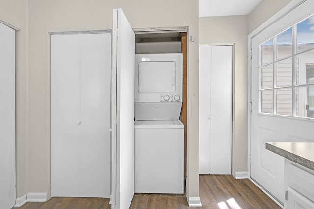 laundry area with stacked washer / dryer and dark wood finished floors