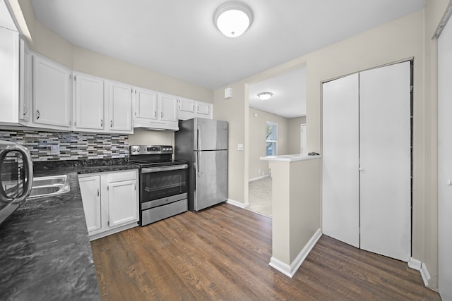 kitchen featuring stainless steel appliances, white cabinetry, dark wood-style flooring, under cabinet range hood, and baseboards