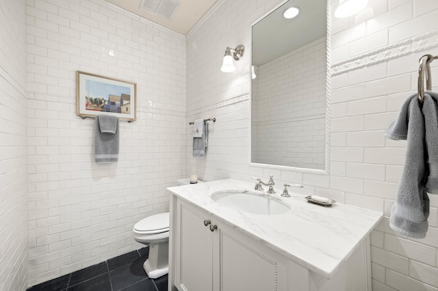 50102 Alpine Blvd, New Buffalo, MI 49117 - bathroom with tile walls, vanity, toilet, and tile patterned floors