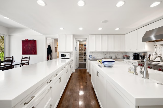 50102 Alpine Blvd, New Buffalo, MI 49117 - kitchen with white microwave, light countertops, wall chimney exhaust hood, dark wood-style floors, and recessed lighting