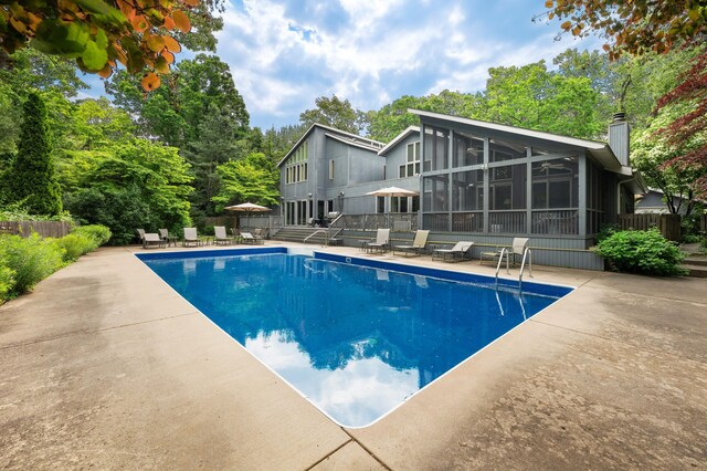 50102 Alpine Blvd, New Buffalo, MI 49117 - swimming pool with a sunroom, a patio, and view of scattered trees