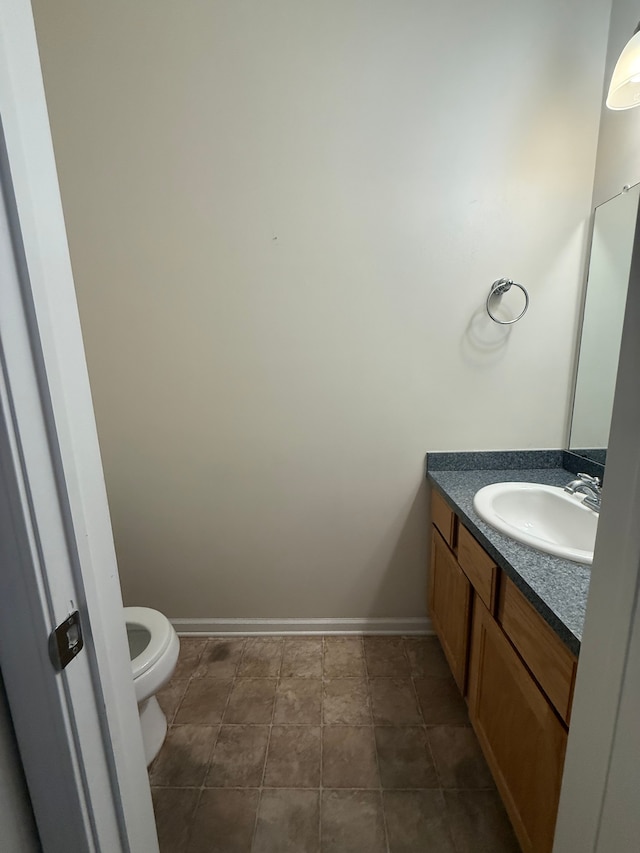 bathroom with vanity, toilet, and baseboards