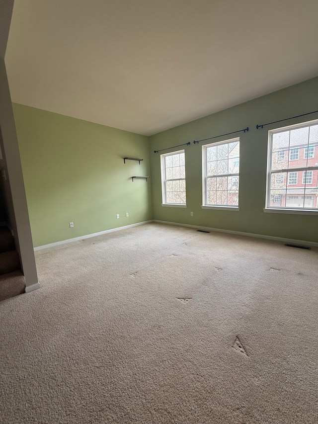 carpeted empty room with baseboards