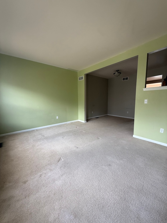 unfurnished room featuring carpet and baseboards
