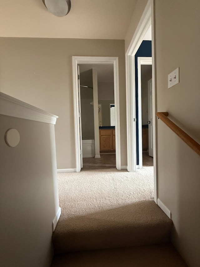 hall featuring carpet and baseboards
