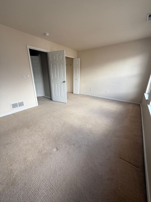 unfurnished bedroom featuring light colored carpet and baseboards