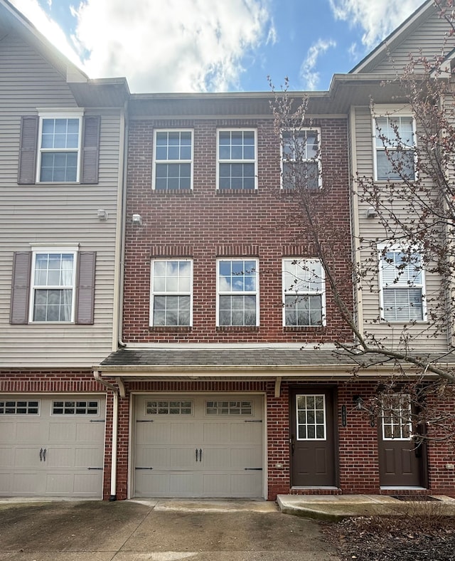 view of front facade featuring a garage, driveway, and brick siding