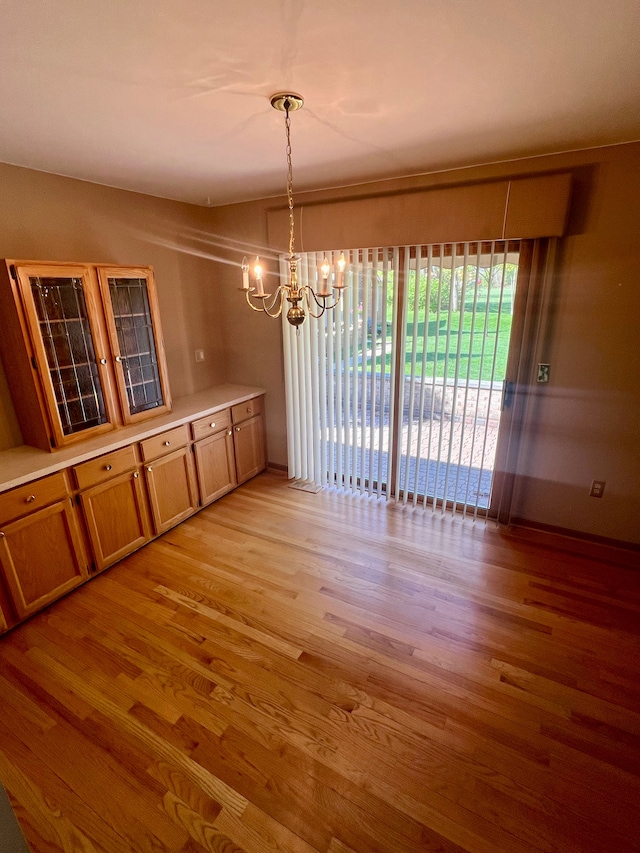 49421 Northwood, Shelby Twp, MI 48315 - unfurnished dining area featuring a chandelier, light wood-style flooring, and baseboards