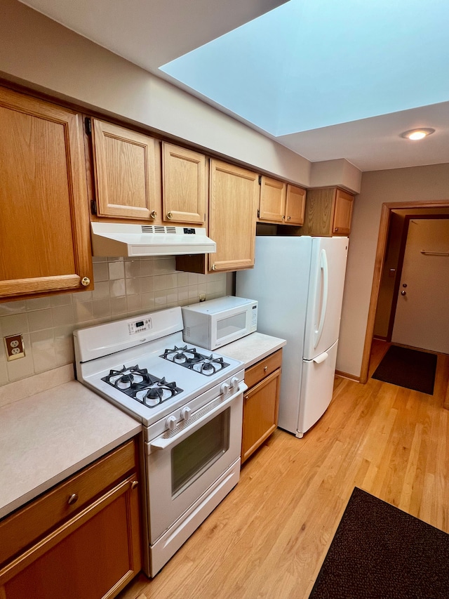 49421 Northwood, Shelby Twp, MI 48315 - kitchen with under cabinet range hood, white appliances, light countertops, light wood-style floors, and backsplash