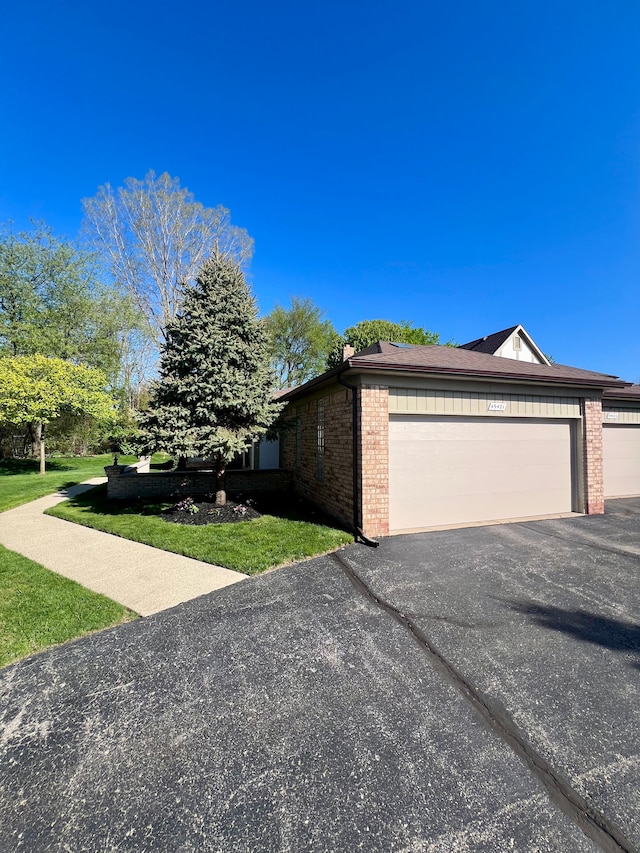 49421 Northwood, Shelby Twp, MI 48315 - view of property exterior featuring brick siding, a garage, driveway, and a lawn