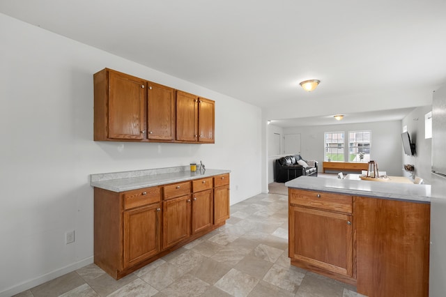 4143 Wild Meadow St, Kalamazoo, MI 49048 - kitchen with brown cabinets, light countertops, open floor plan, and a peninsula