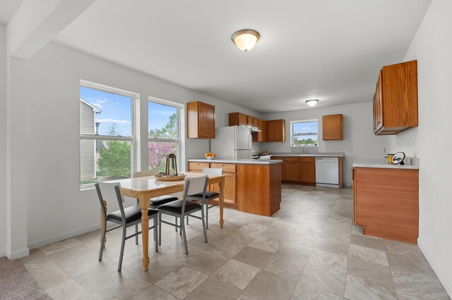 4143 Wild Meadow St, Kalamazoo, MI 49048 - kitchen featuring white appliances, brown cabinets, light countertops, baseboards, and a sink