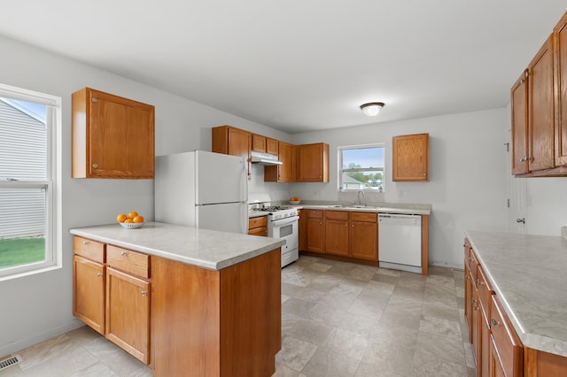4143 Wild Meadow St, Kalamazoo, MI 49048 - kitchen with white appliances, a peninsula, under cabinet range hood, a sink, and light countertops