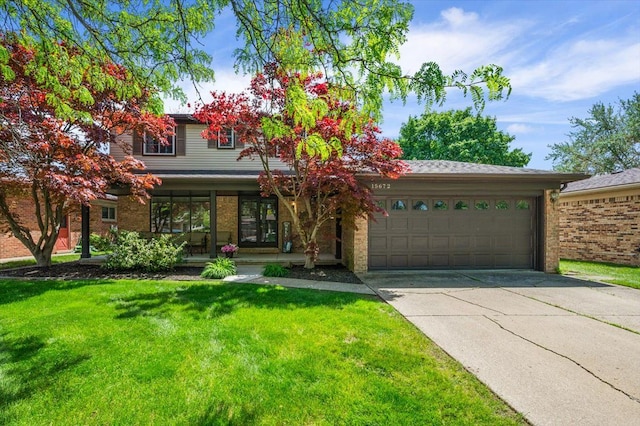 15672 Robert Dr, Macomb, MI 48044 - view of front of property with an attached garage, brick siding, concrete driveway, a front yard, and a porch