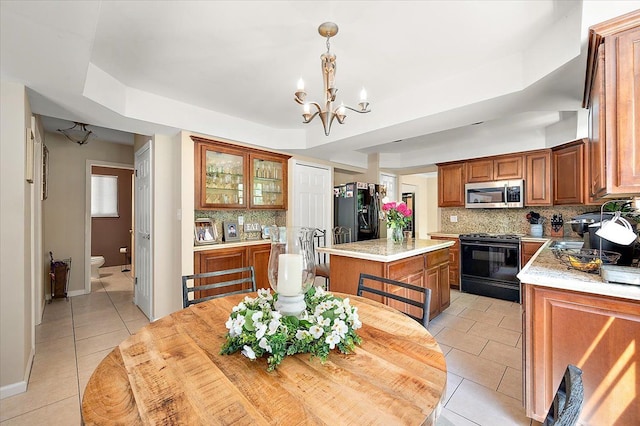 15672 Robert Dr, Macomb, MI 48044 - kitchen featuring black appliances, light tile patterned floors, tasteful backsplash, light countertops, and a chandelier