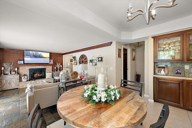 15672 Robert Dr, Macomb, MI 48044 - dining space featuring a chandelier and a brick fireplace