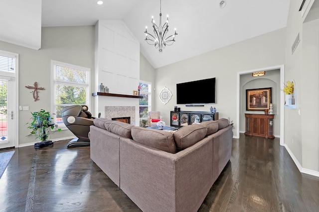 living area with high vaulted ceiling, plenty of natural light, a chandelier, a fireplace, and baseboards