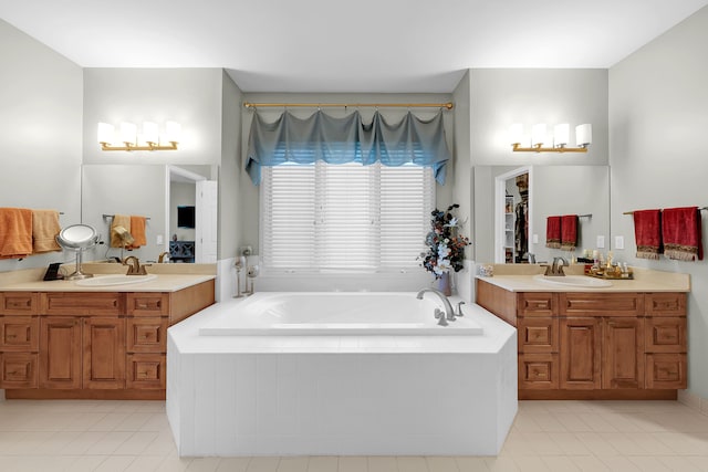 bathroom featuring tile patterned floors, a garden tub, and two vanities