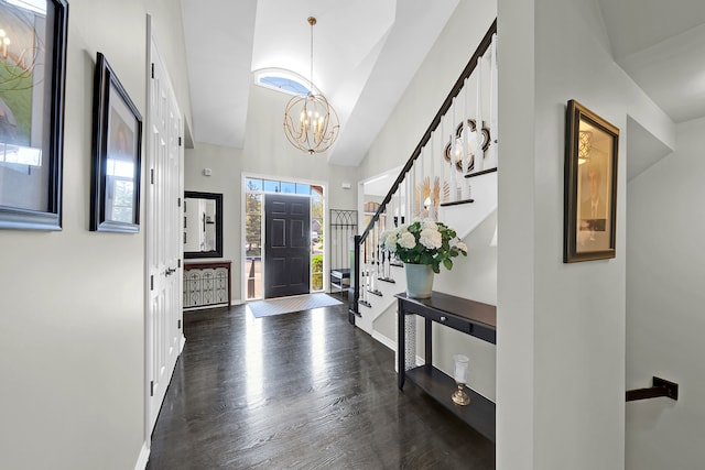 foyer entrance featuring a chandelier, wood finished floors, a high ceiling, baseboards, and stairway