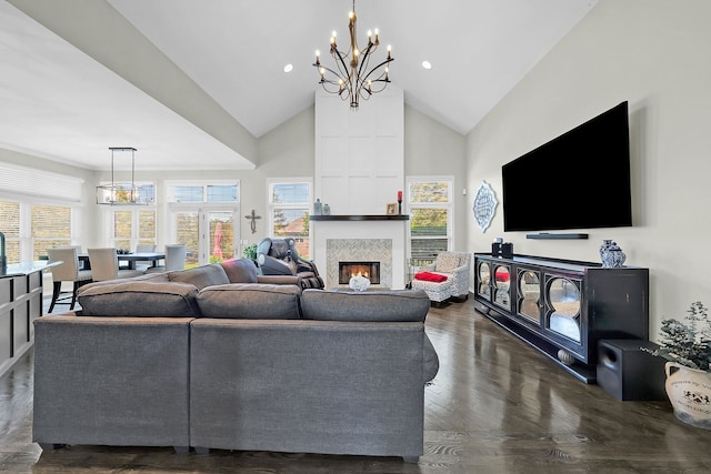 living room with a chandelier, high vaulted ceiling, a fireplace, dark wood-style flooring, and recessed lighting