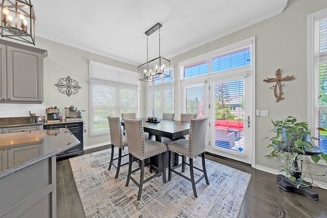dining area featuring a chandelier, plenty of natural light, baseboards, and crown molding