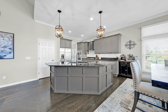 kitchen with stainless steel fridge, gray cabinetry, wall chimney range hood, healthy amount of natural light, and crown molding