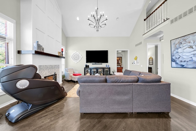 living area featuring high vaulted ceiling, a chandelier, dark wood-type flooring, baseboards, and a tile fireplace