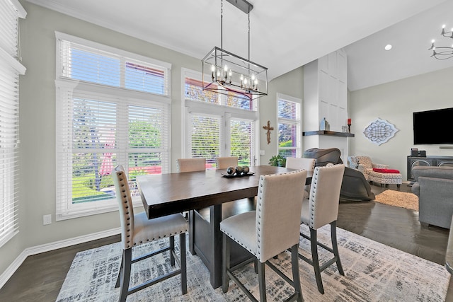 dining space featuring a chandelier, healthy amount of natural light, a towering ceiling, and baseboards