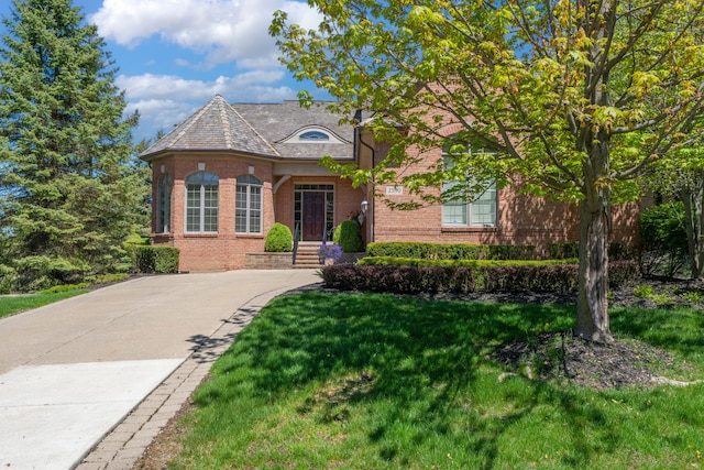 view of front of property featuring brick siding and a front lawn
