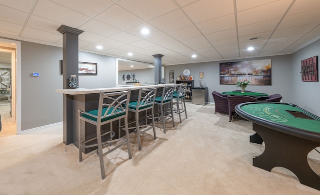 rec room featuring light colored carpet, a bar, baseboards, recessed lighting, and decorative columns