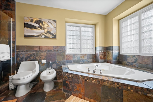 47352 Dove Ct, Shelby Twp, MI 48315 - bathroom featuring toilet, a garden tub, tile walls, wainscoting, and a bidet