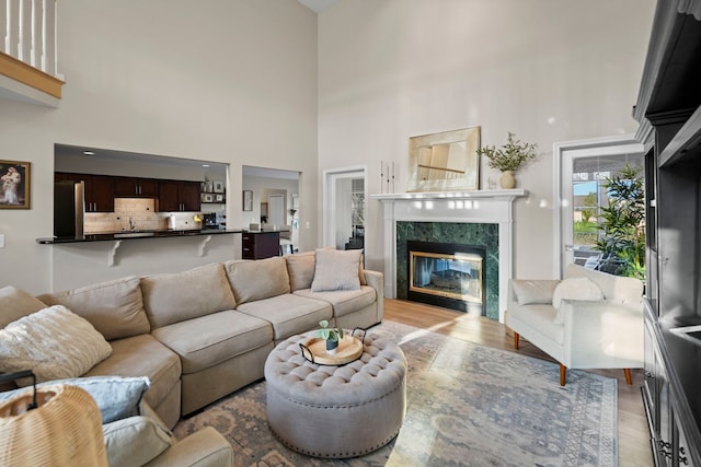 47352 Dove Ct, Shelby Twp, MI 48315 - living room featuring light wood-style floors, a high ceiling, and a fireplace