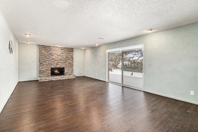 4819 Thorntree Dr, West Bloomfield, MI 48322 - unfurnished living room featuring dark wood-style flooring, a stone fireplace, a textured ceiling, and baseboards