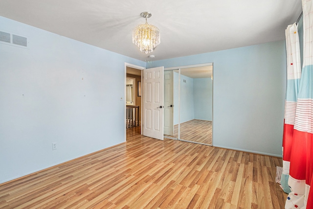 4819 Thorntree Dr, West Bloomfield, MI 48322 - unfurnished bedroom with wood finished floors, a chandelier, and a closet